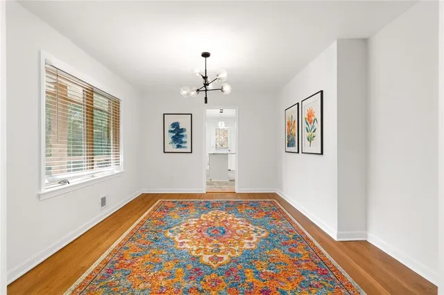 a view of an empty room with window and wooden floor
