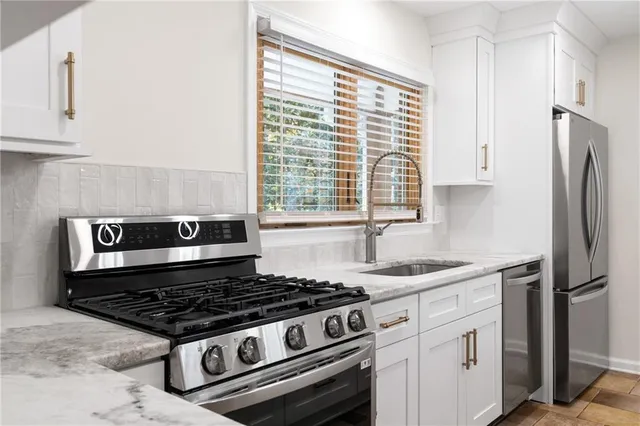 a kitchen with stainless steel appliances granite countertop a sink stove and refrigerator