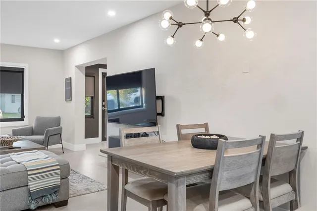 a living room with furniture and a refrigerator