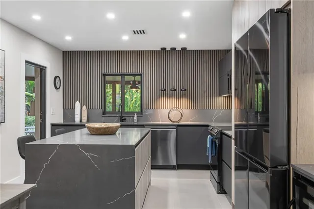 a kitchen with granite countertop a sink a stove and cabinets