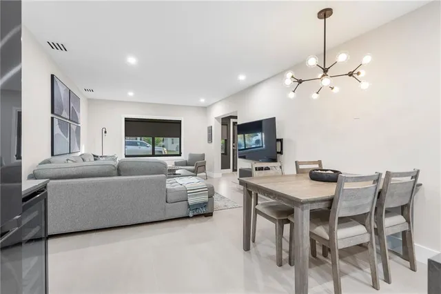 a living room with furniture a chandelier and a flat screen tv
