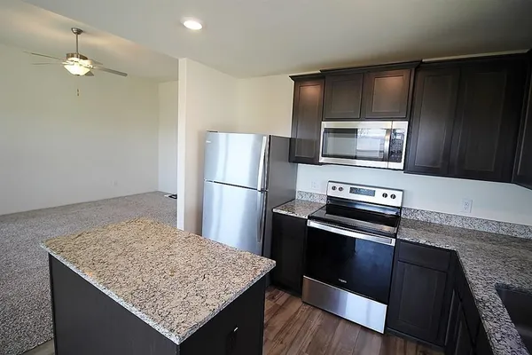 a kitchen with granite countertop wooden cabinets and stainless steel appliances