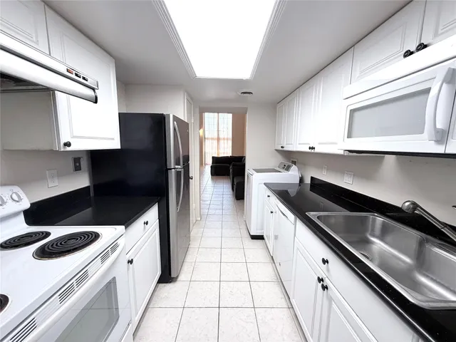 a kitchen with granite countertop a sink stove and refrigerator