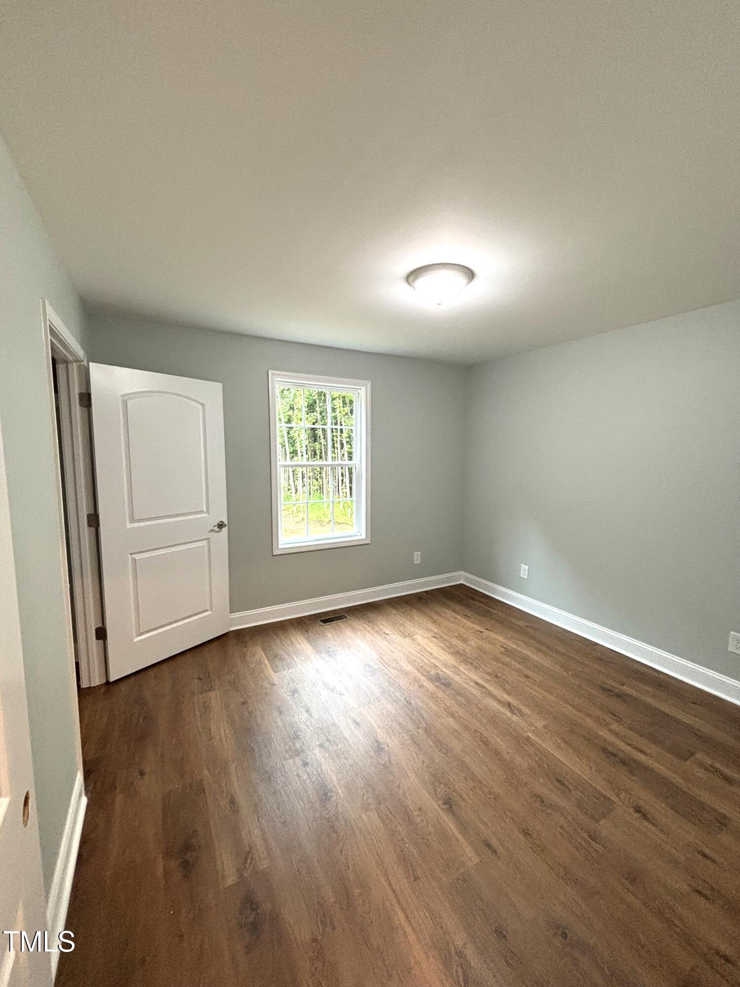 2665 Bodie Currin Road Oxford, NC 27565 - Photo 21 of 26 an empty room with wooden floor and windows