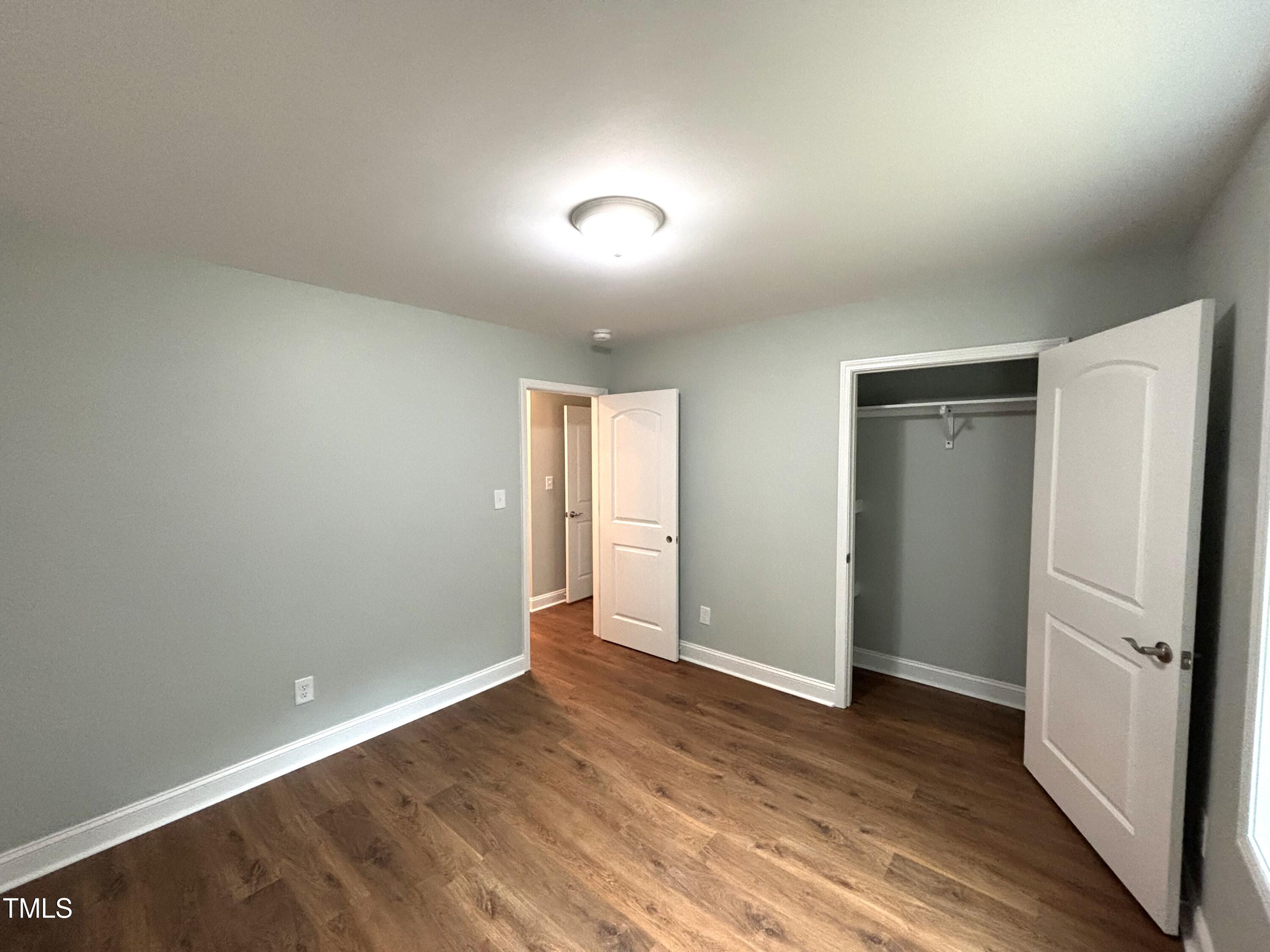 2665 Bodie Currin Road Oxford, NC 27565 - Photo 22 of 26 an empty room with wooden floor and a bathroom
