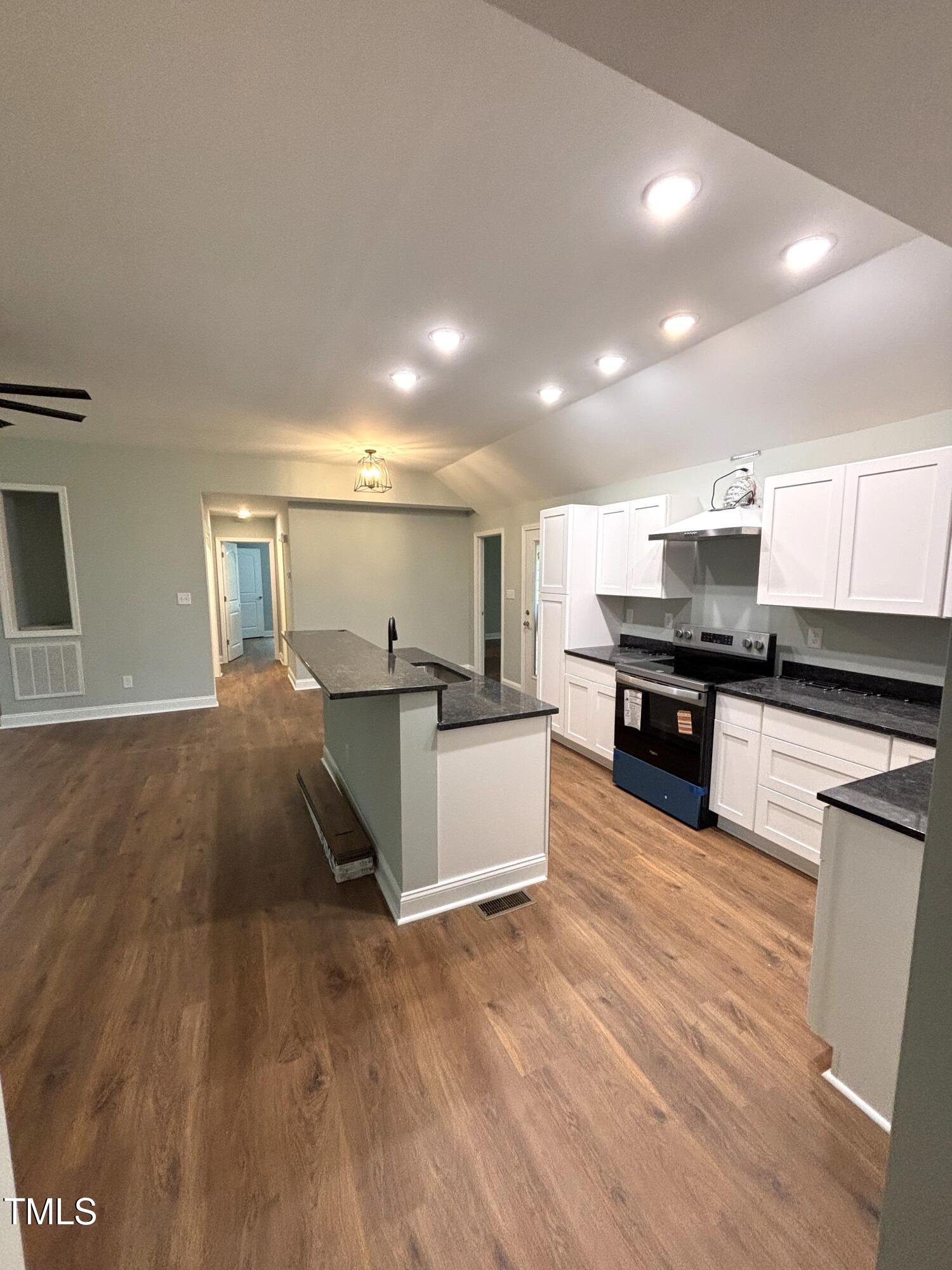 2665 Bodie Currin Road Oxford, NC 27565 - Photo 7 of 26 a large kitchen with stainless steel appliances granite countertop a stove a sink and a microwave