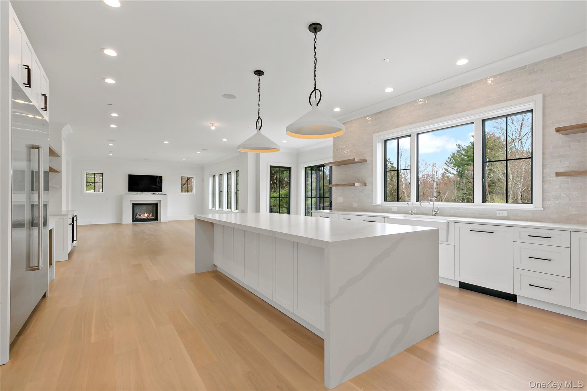 115 Old Roaring Brook Road Mount Kisco, NY 10549 - Photo 11 of 25 a large kitchen with kitchen island a stove a sink a center island and windows