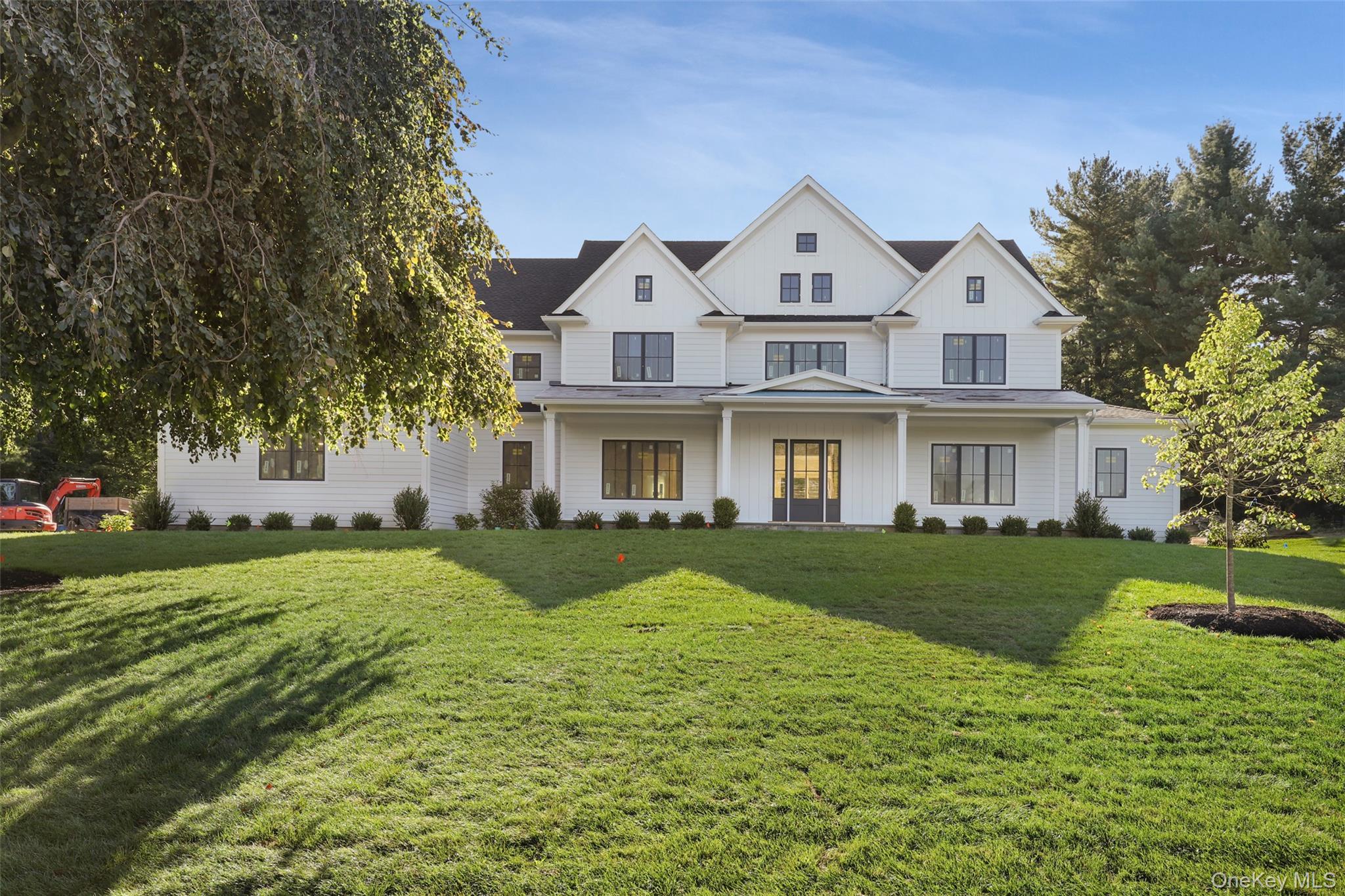 115 Old Roaring Brook Road Mount Kisco, NY 10549 - Photo 6 of 25 a front view of a house with a yard and garage