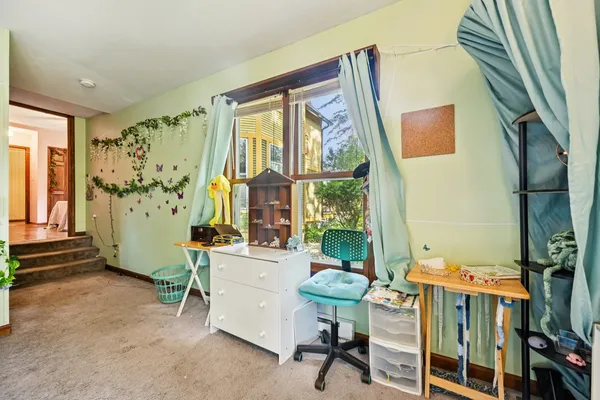 a view of a bedroom with wooden floor and windows
