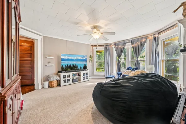 a bed sitting in a spacious bedroom next to a window