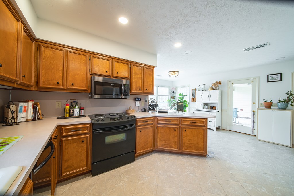 4856 Spring Ridge Drive Columbus, GA 31909 - Photo 13 of 41 a kitchen with stainless steel appliances granite countertop a stove top oven a sink dishwasher a refrigerator and cabinets with wooden floor