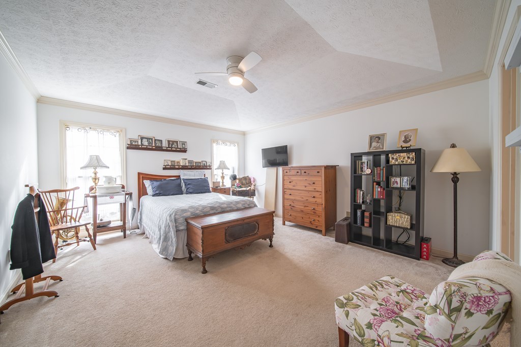 4856 Spring Ridge Drive Columbus, GA 31909 - Photo 18 of 41 a bedroom with a large bed and a chandelier