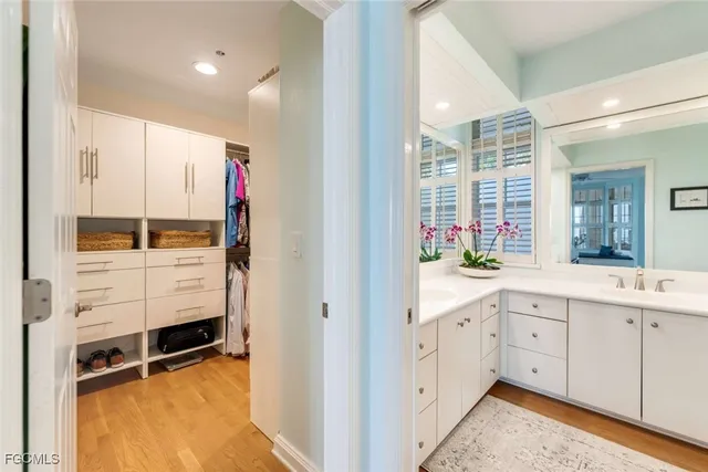 a hallway with white cabinets and wooden floor