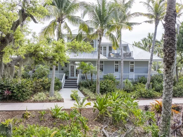 a front view of a house with a yard and fountain in middle