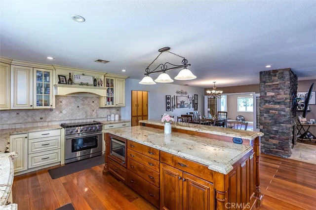 a kitchen with stainless steel appliances granite countertop a stove and cabinets