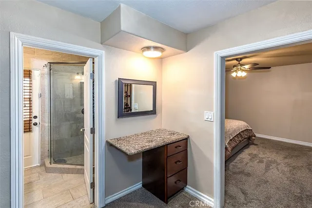 a bathroom with a granite countertop sink and shower
