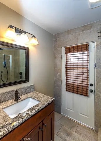 a bathroom with a granite countertop sink and a mirror