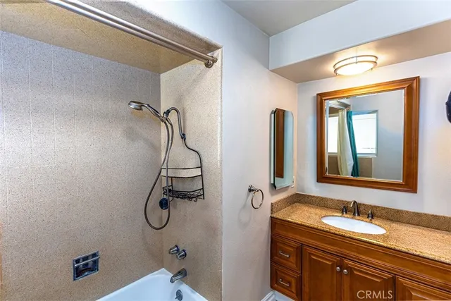 a bathroom with a granite countertop sink a toilet and mirror