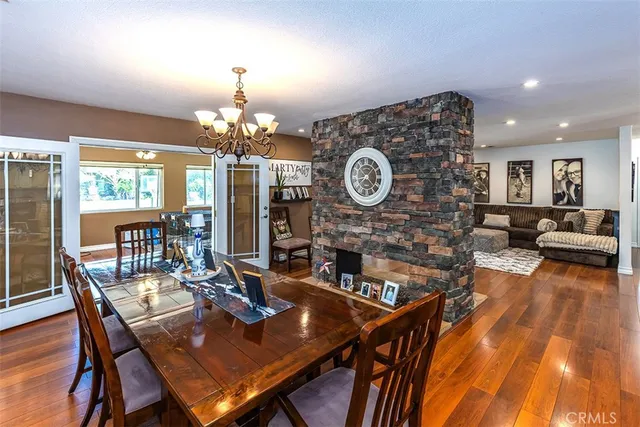 a view of a dining room with furniture a chandelier and wooden floor