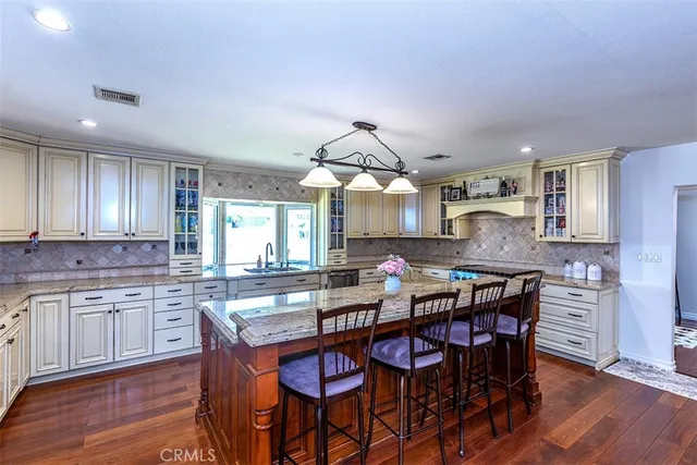 a kitchen with a dining table chairs and wooden floor