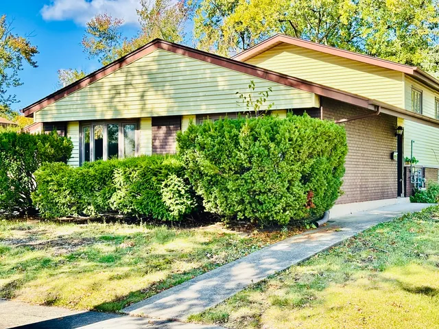 a front view of a house with a yard and potted plants