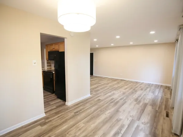 an empty room with wooden floor and entrance