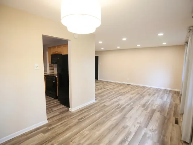 an empty room with wooden floor and entrance