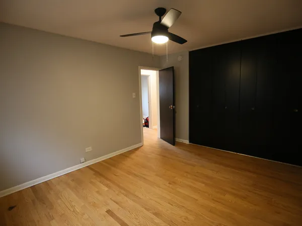 a view of an empty room with a chandelier fan