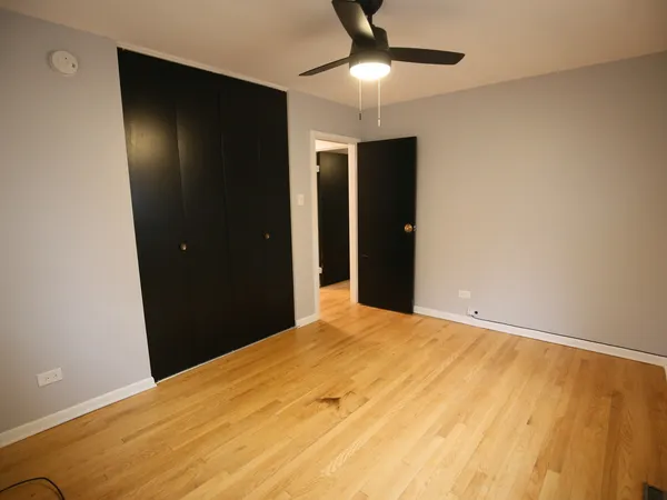 a view of an empty room with a chandelier fan