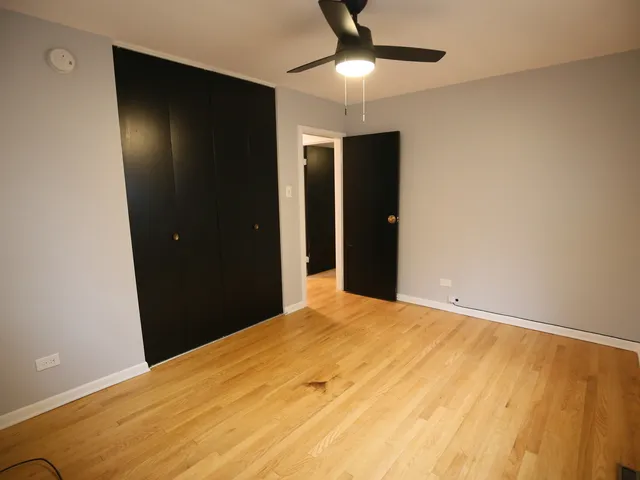 a view of an empty room with a chandelier fan