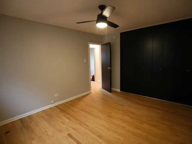 a view of an empty room with a chandelier fan
