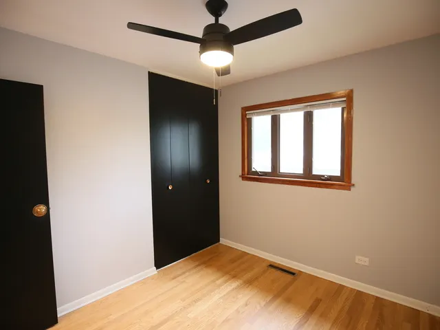 a view of an empty room with window and closet area
