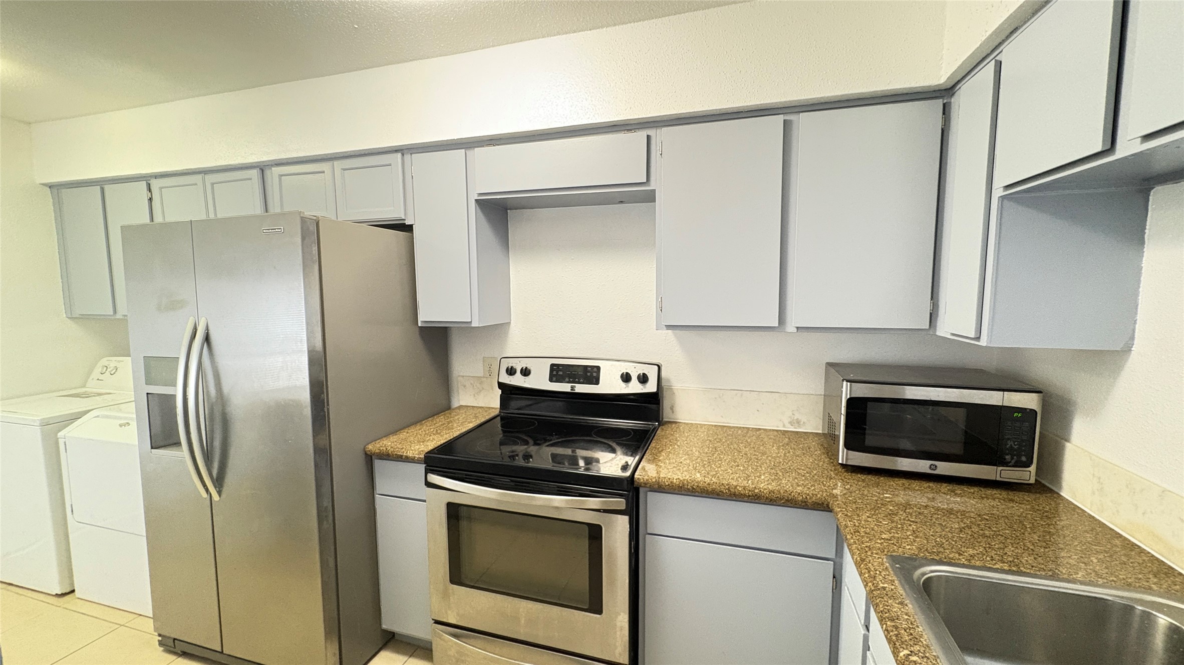 6633 West Airport Boulevard, Unit 101 Houston, TX 77035 - Photo 17 of 25 a kitchen with stainless steel appliances granite countertop a refrigerator sink and stove