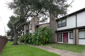 6633 West Airport Boulevard, Unit 101 Houston, TX 77035 - Photo 25 of 25 a view of an brick house with a large windows and a large tree