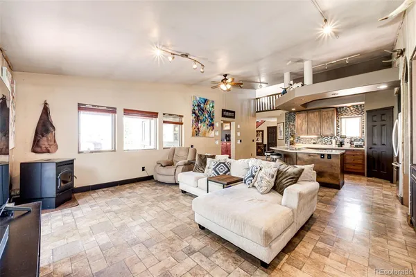 a living room with furniture kitchen view and a window