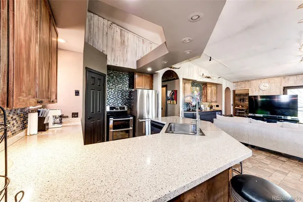 a large kitchen with sink a counter top space and stainless steel appliances