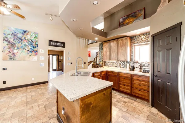 a kitchen with stainless steel appliances kitchen island granite countertop a refrigerator and a stove top oven