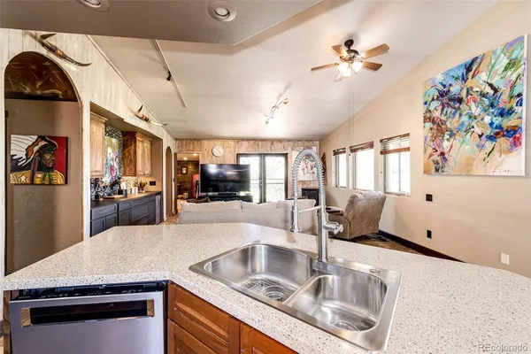 a kitchen with stainless steel appliances granite countertop a sink dishwasher and a stove with wooden floor