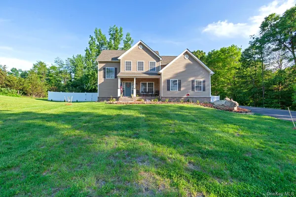 a front view of a house with a yard and trees