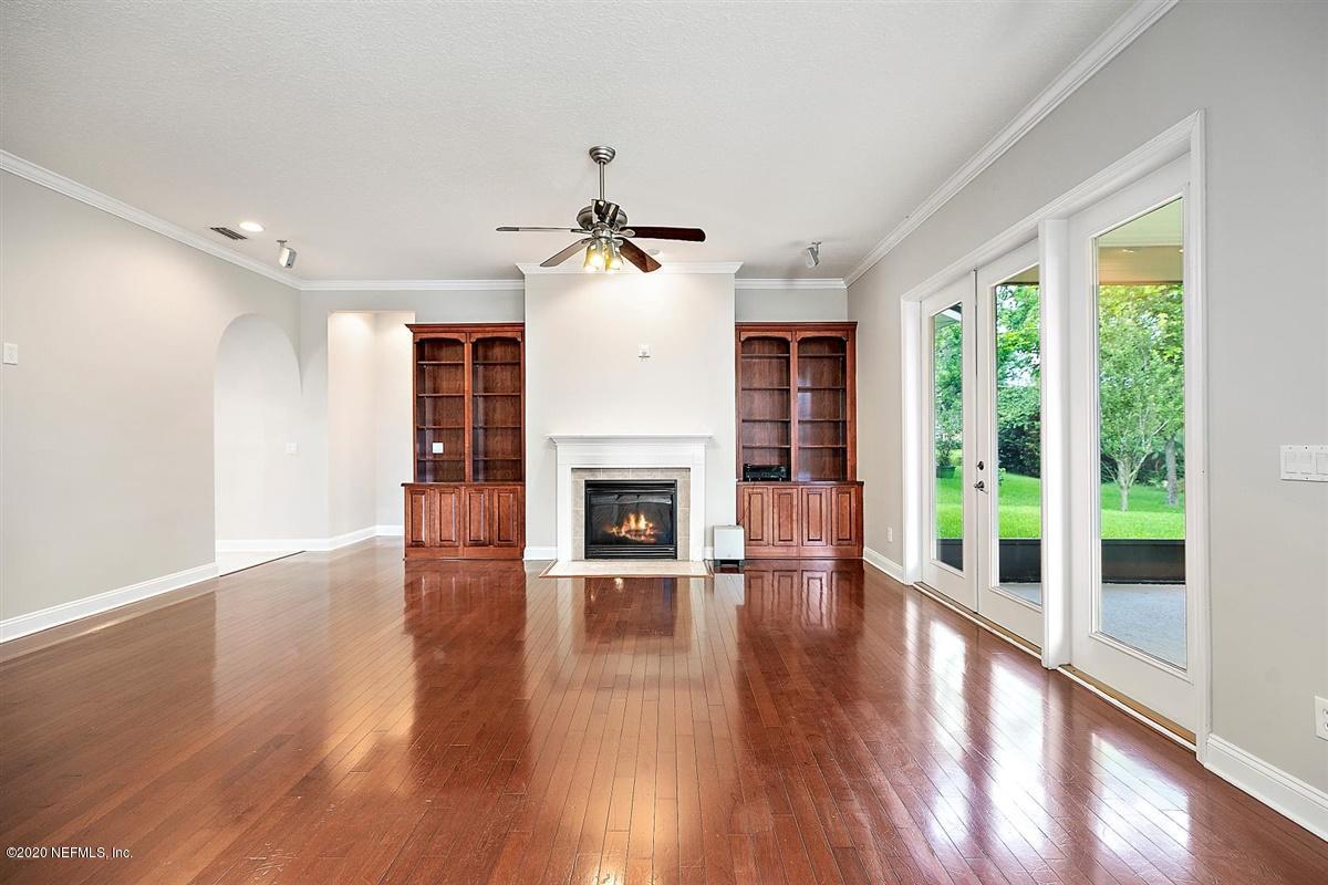 1320 Powis Road St. Augustine, FL 32095 - Photo 8 of 32 a view of a livingroom with wooden floor a fireplace and windows