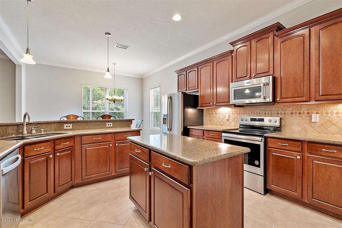 1320 Powis Road St. Augustine, FL 32095 - Photo 10 of 32 a kitchen with stainless steel appliances granite countertop wooden cabinets a stove a sink and a refrigerator