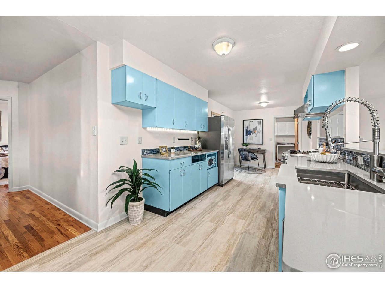 805 Colorado Street Fort Collins, CO 80524 - Photo 14 of 45 a kitchen with stainless steel appliances kitchen island granite countertop a refrigerator a stove a sink dishwasher and white cabinets with wooden floor