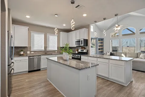 a kitchen with counter top space a sink cabinets and appliances