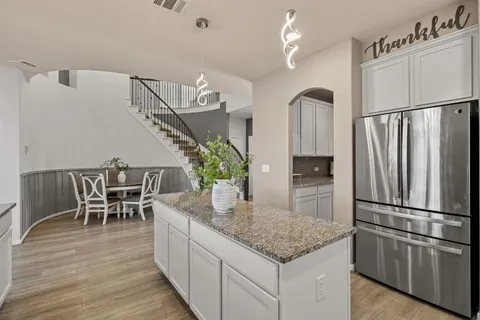 a kitchen with stainless steel appliances granite countertop furniture wooden floor and a refrigerator