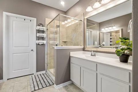 a bathroom with a double vanity sink mirror and shower