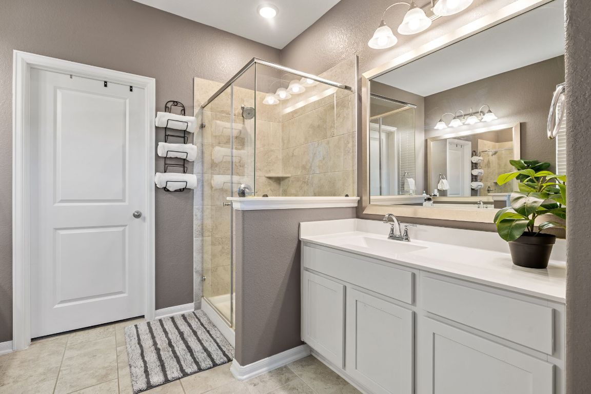 408 Ravello Street Liberty Hill, TX 78642 - Photo 18 of 40 a bathroom with a double vanity sink mirror and shower