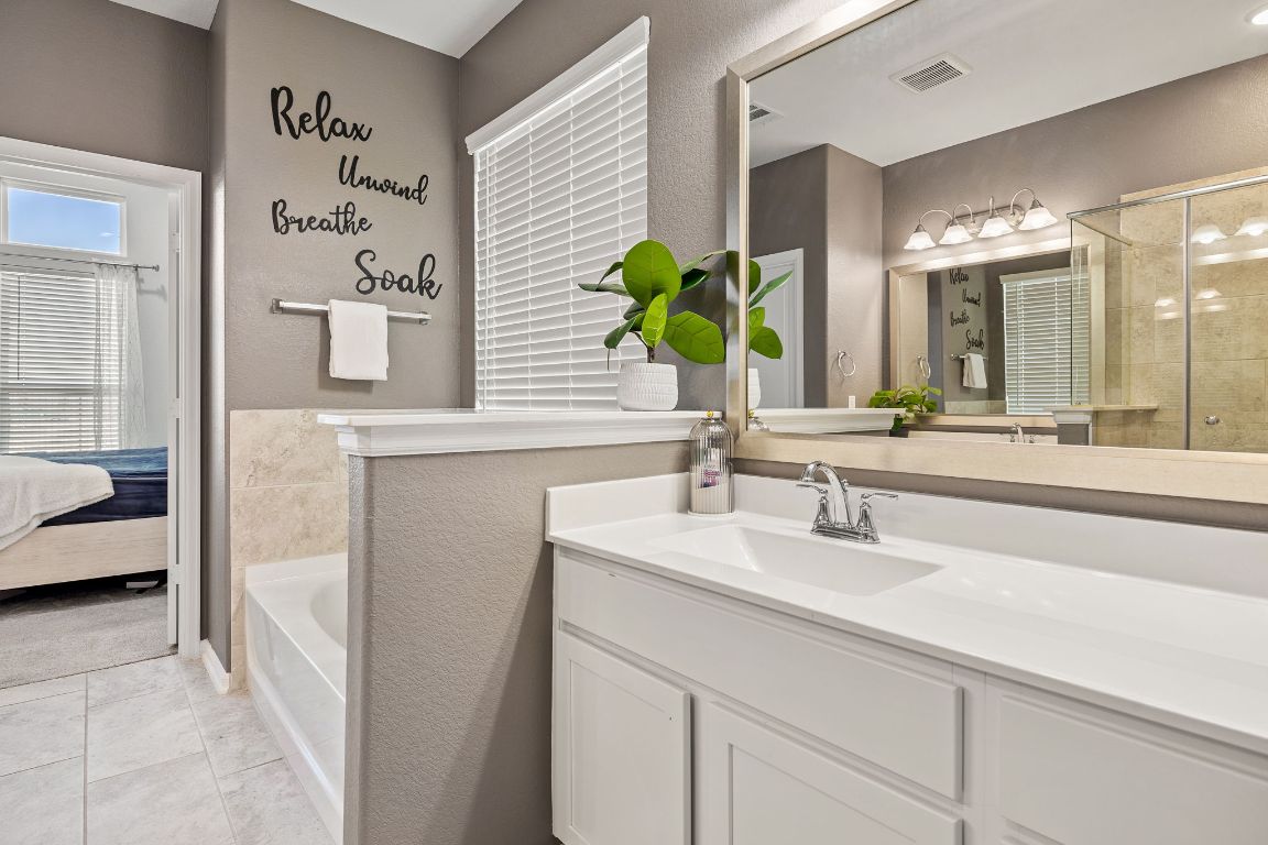 408 Ravello Street Liberty Hill, TX 78642 - Photo 19 of 40 a bathroom with a double vanity sink and a mirror