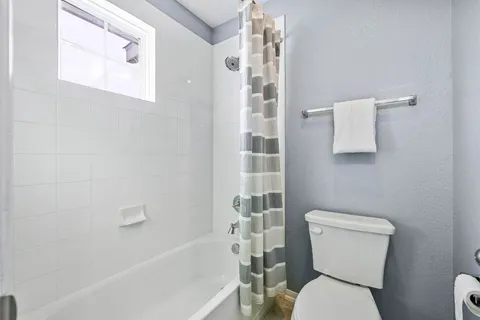 a white toilet sitting next to a bath tub