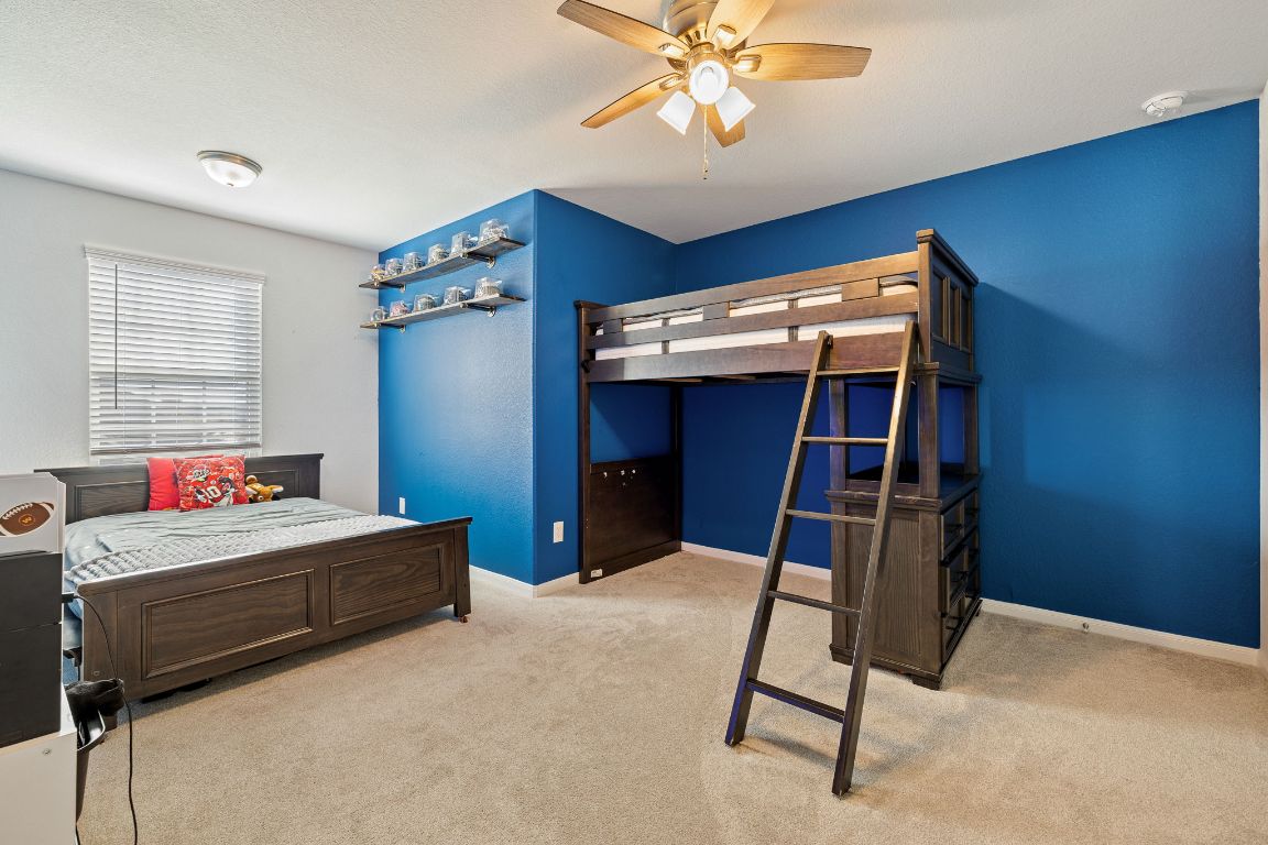 408 Ravello Street Liberty Hill, TX 78642 - Photo 26 of 40 a bedroom with a bed and a chandelier