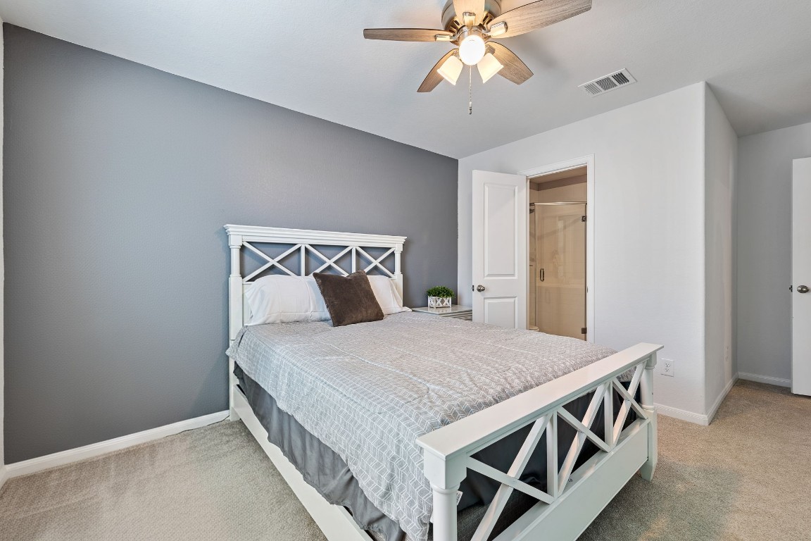 408 Ravello Street Liberty Hill, TX 78642 - Photo 27 of 40 a bedroom with a bed and a chandelier